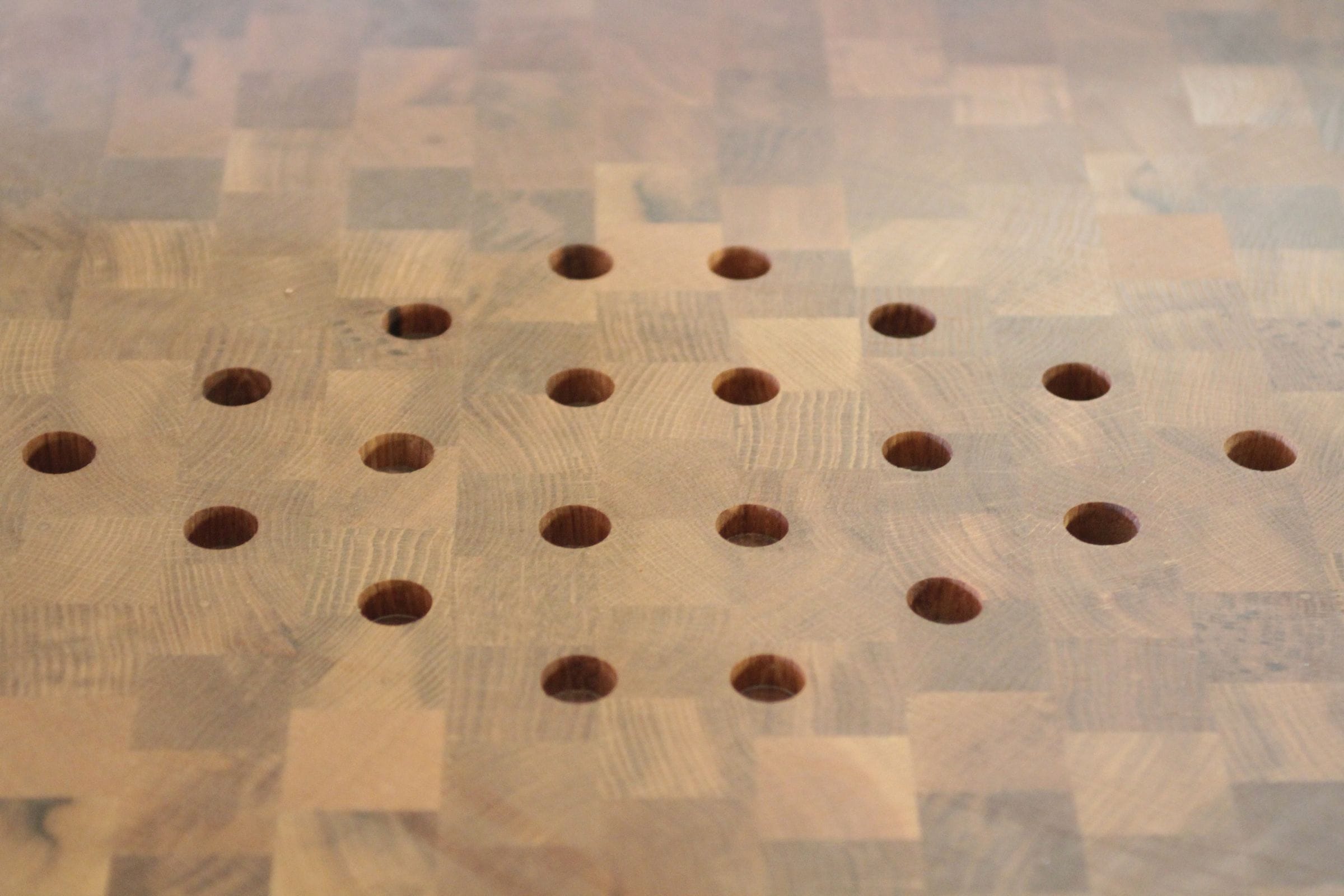 Drilled drainage holes in an end grain oak chopping block surface