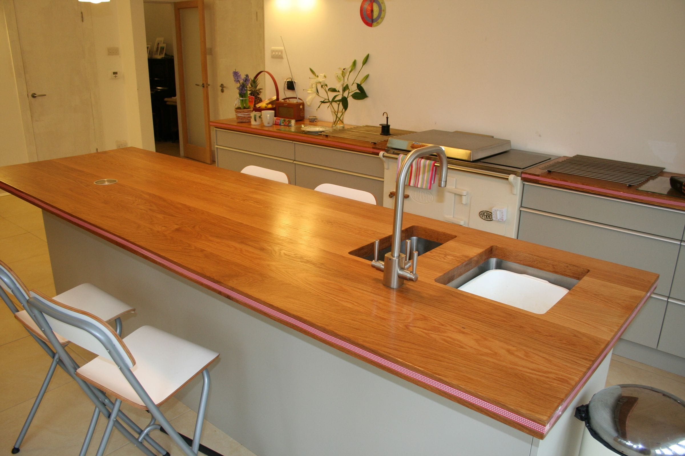 Oak island worktop with twin inset sinks and mixer tap in a modern grey kitchen