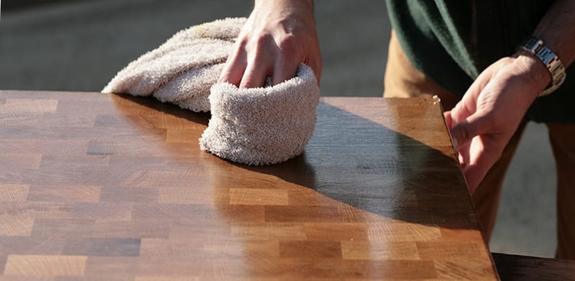 Hand buffing oil into an end grain walnut worktop with a soft cloth