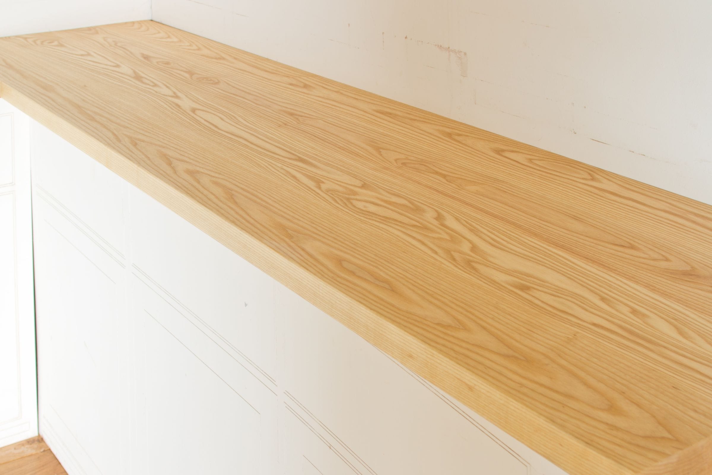 Pale American ash worktop with flowing grain on white painted cabinets