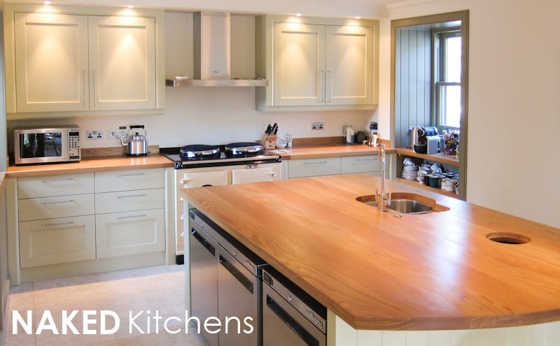 Pale painted NAKED Kitchens design with a curved oak worktop island
