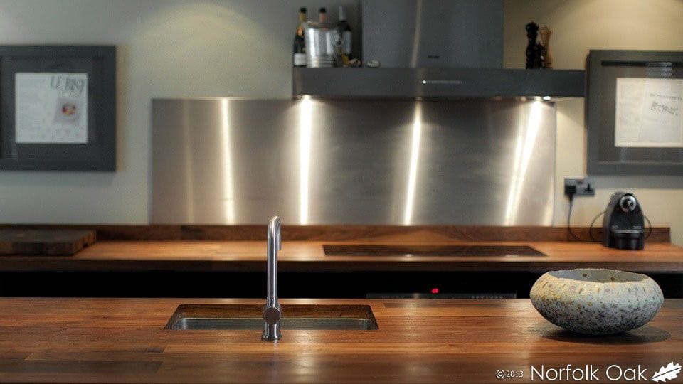 Dark walnut worktop with undermounted sink and stainless steel splashback