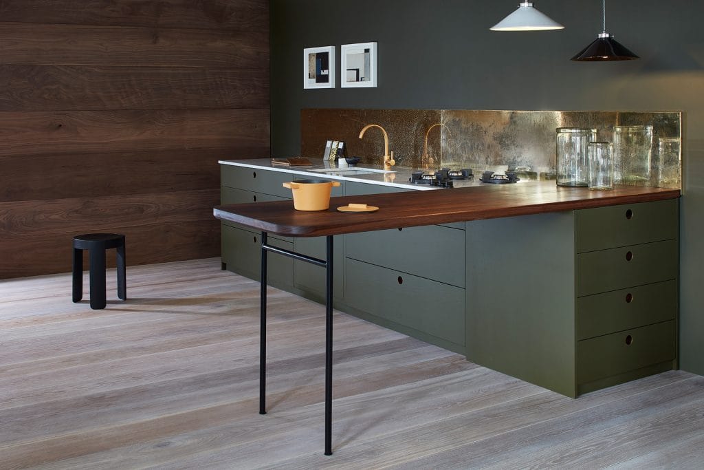 Olive green kitchen with walnut breakfast bar, marble worktop and aged brass splashback