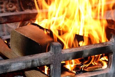 Wood briquette burning in an open fire grate