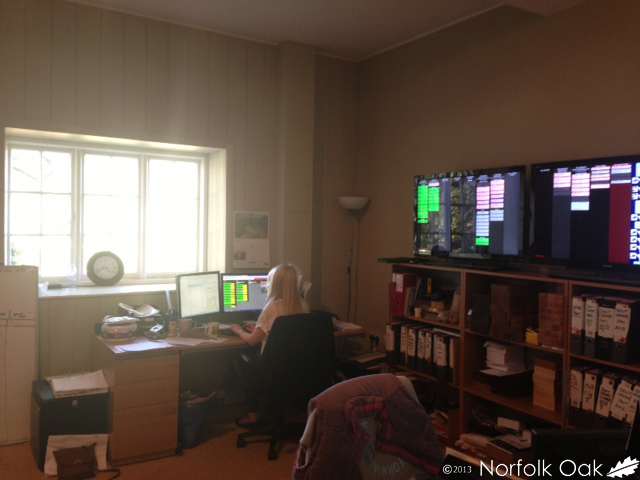 Staff member working at a desk in the Norfolk Oak office with wall-mounted screens