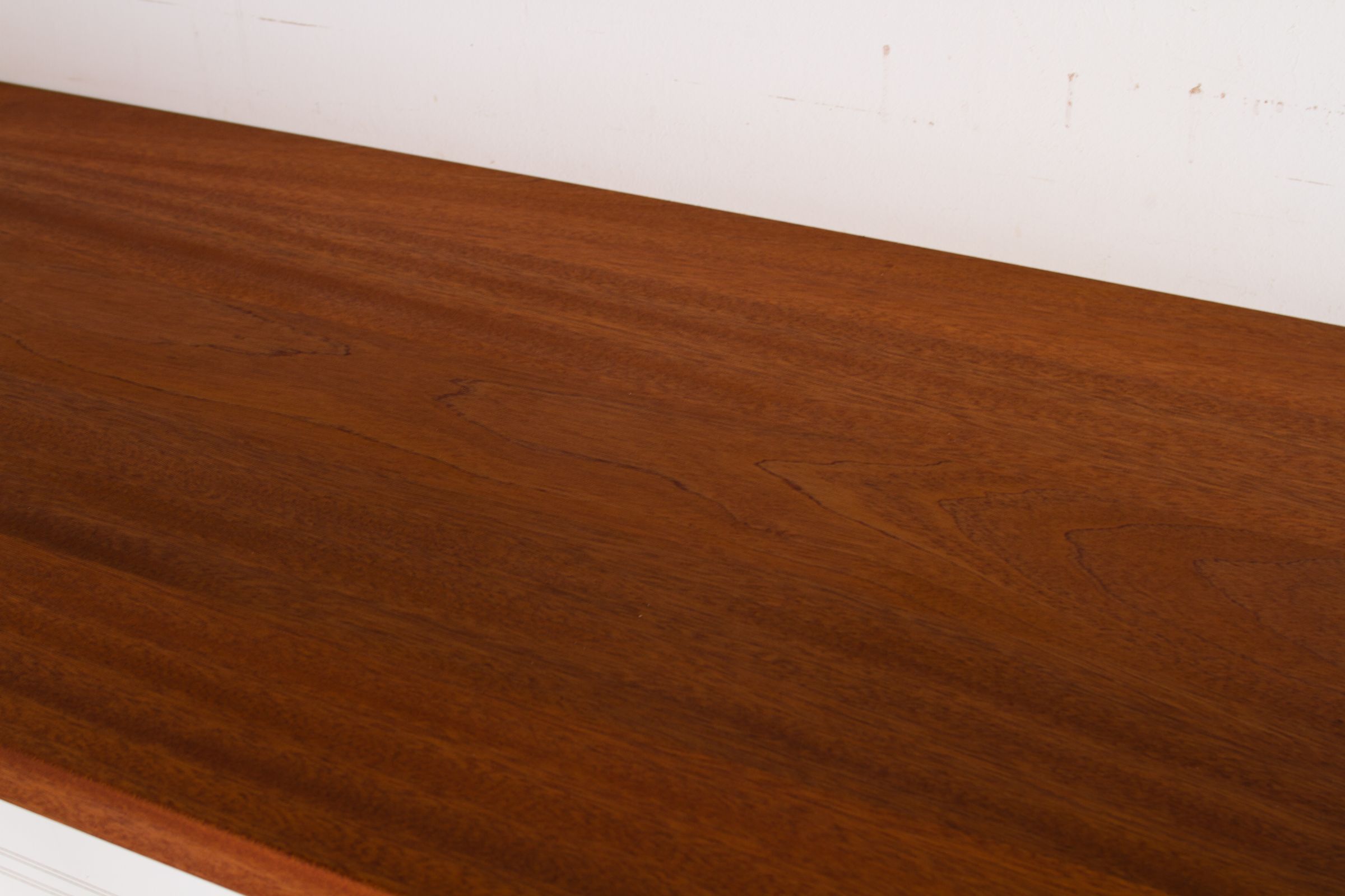 West African mahogany worktop with straight reddish-brown grain against a white wall