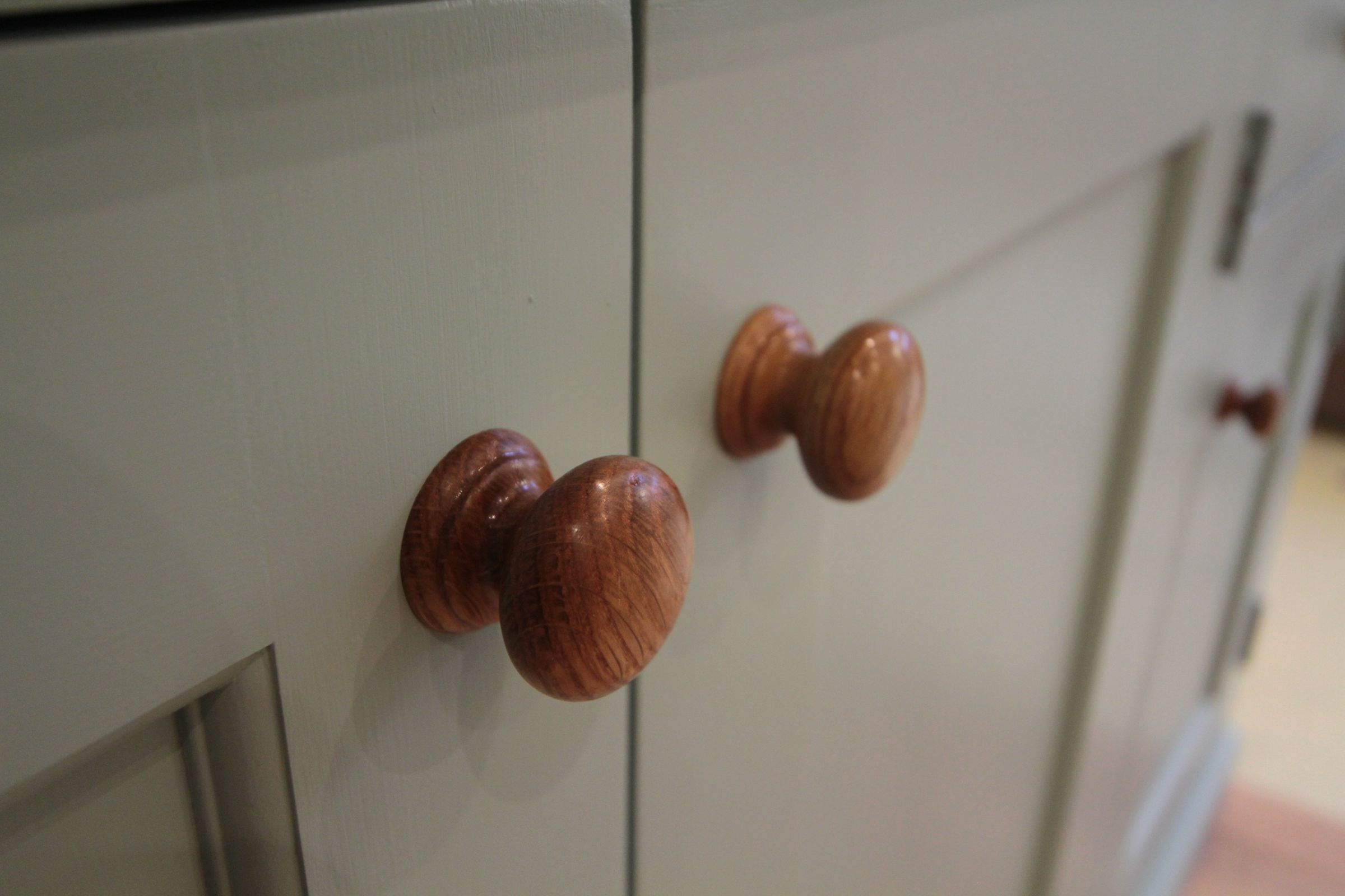 Hand Turned Knobs Hand-turned oak cabinet knobs on pale grey painted doors