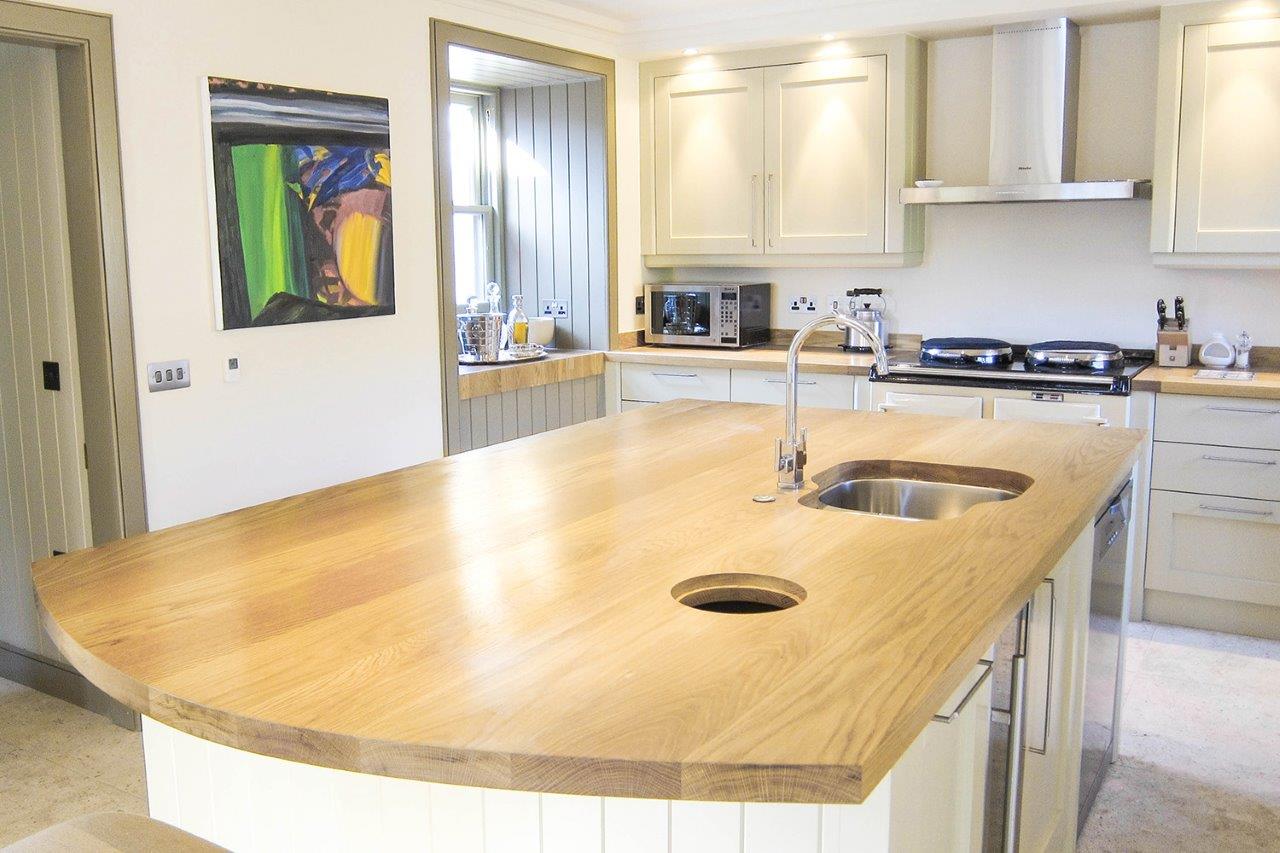 affric-bepoke-kitchen Curved oak island worktop with undermounted sink in a pale painted kitchen