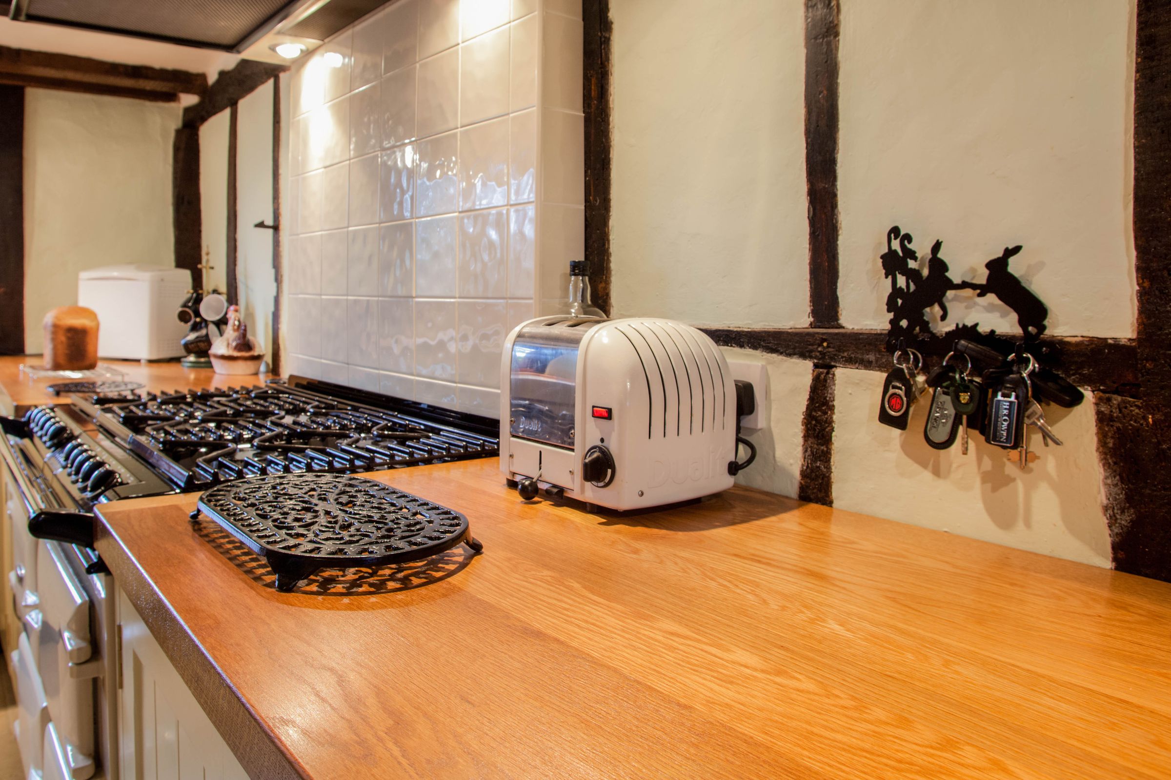 oak-kitchen-worktop Oak worktop with a white toaster beside a range cooker in a timber-framed kitchen