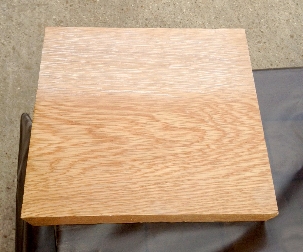 Square oak sample board with whitewash applied to the top half, bare timber below