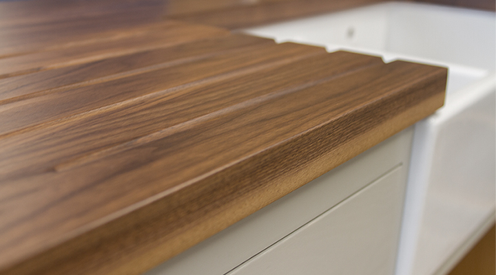 walnut worktops drainage grooves Close-up of drainage grooves carved into a walnut worktop beside a white ceramic sink
