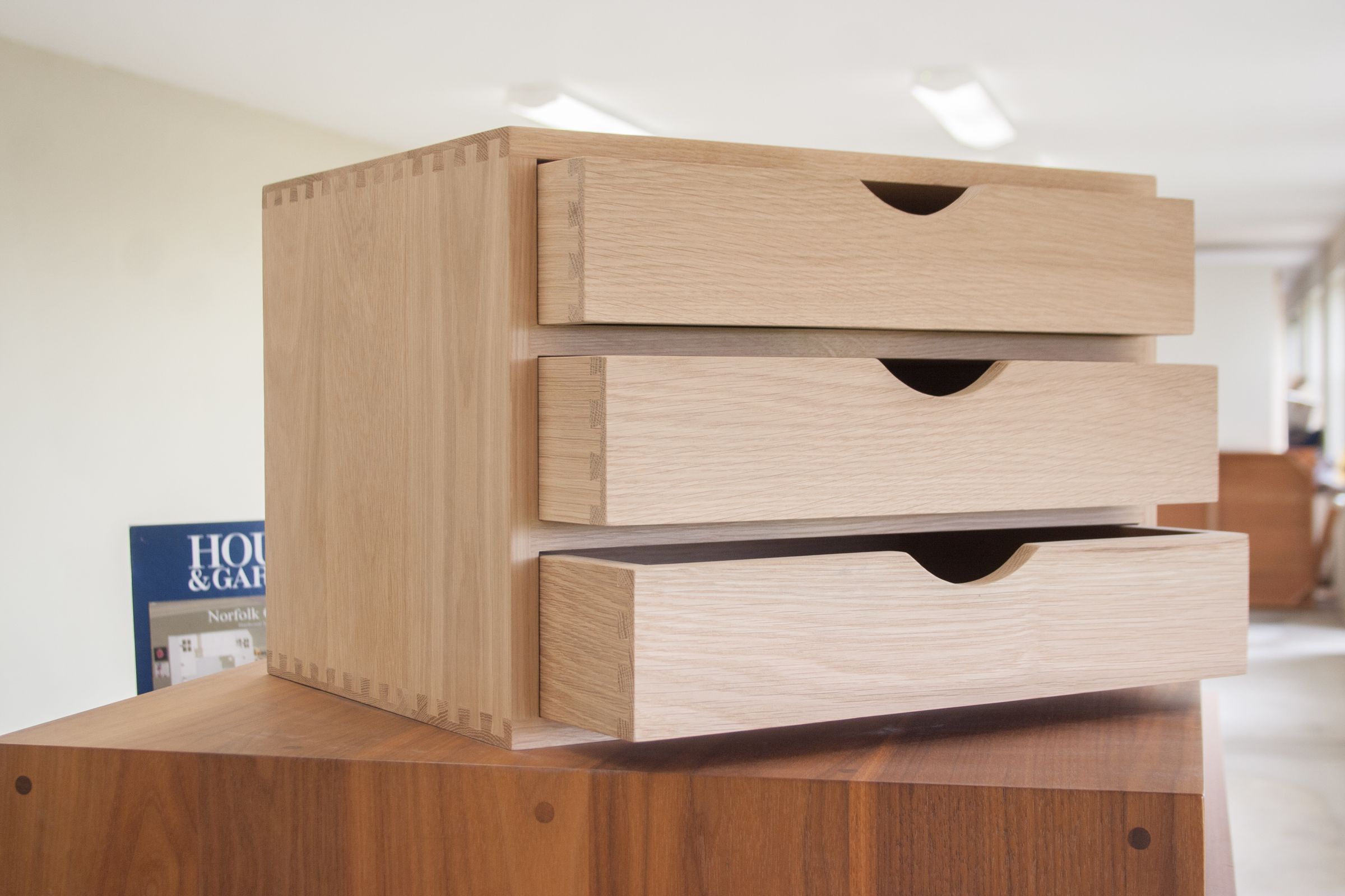 Dovetailed oak filing box with three drawers pulled open at staggered depths