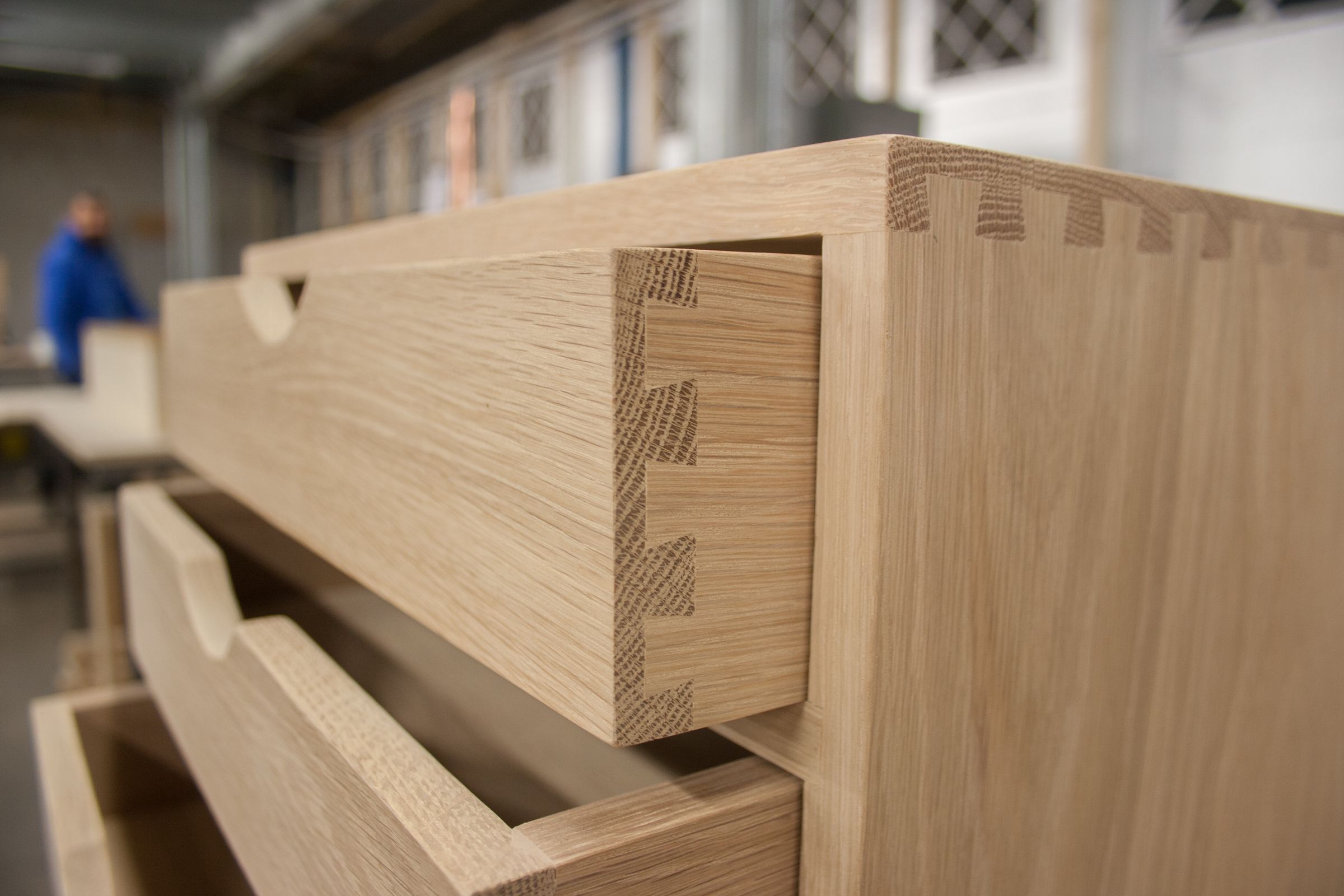 Close-up of precise dovetail joints on an open oak drawer box