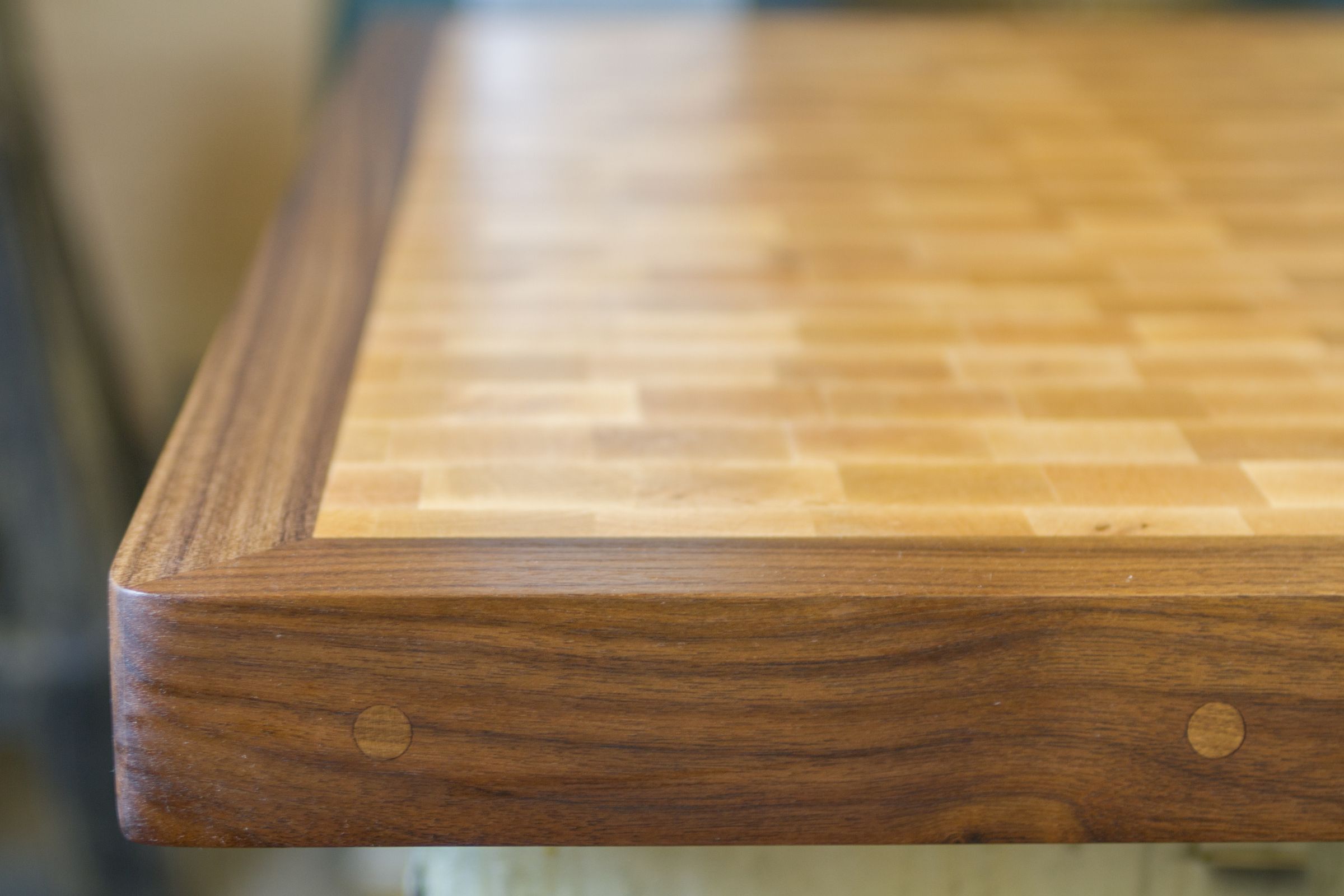 end grain maple walnut surround chopping block Corner of a maple end grain chopping block framed by a black walnut surround