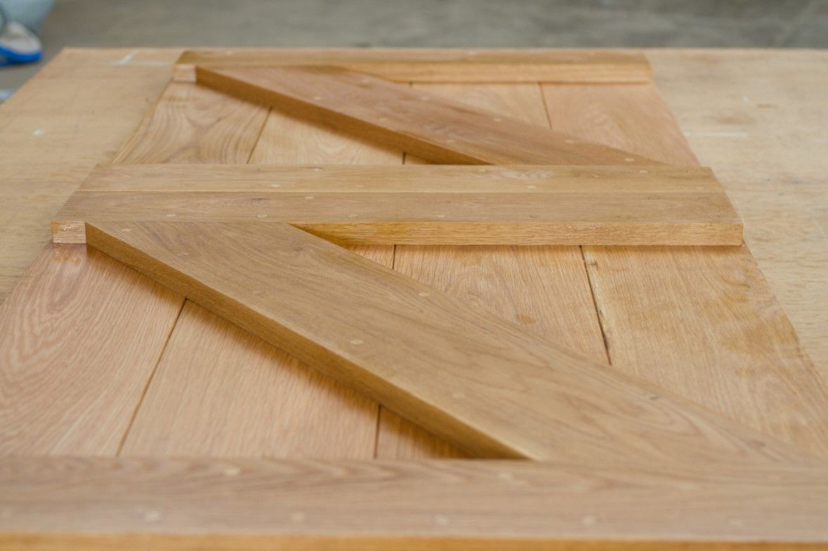Solid oak stable door panels with diagonal frame bracing laid out in the workshop